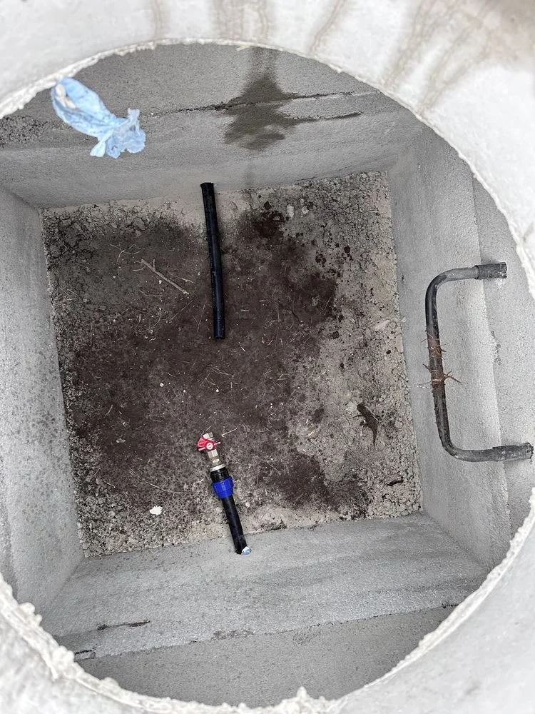 Cămin de beton cu trepte și conducte de apă instalate